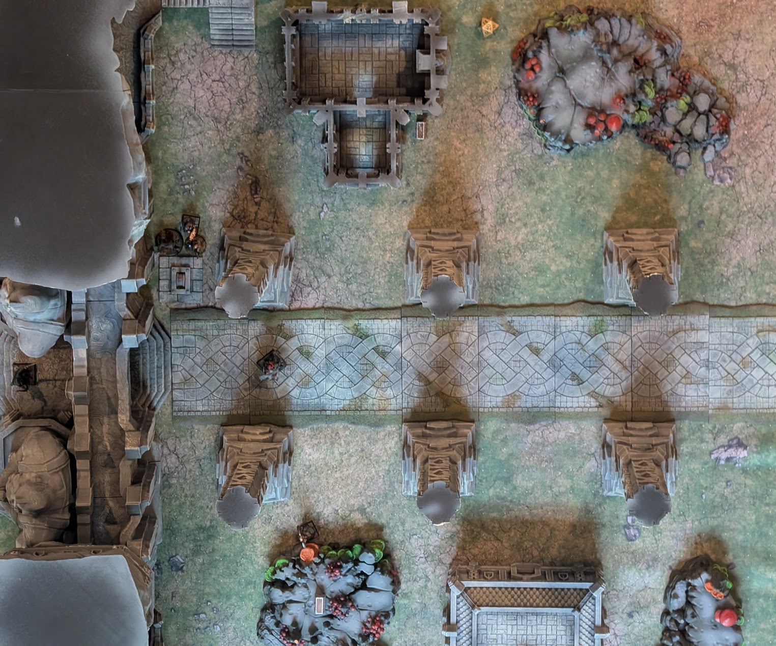 Overhead view of the Underway battlefield, with a stone road crossing between tall pillars, rocky ground, and stairways.